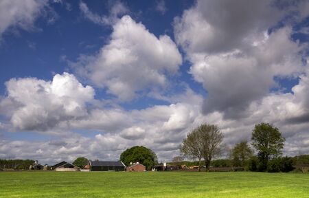 Landscape with farm buildings under large white clouds near the Dutch village Bornerbroeknear Bornerbroekの写真素材