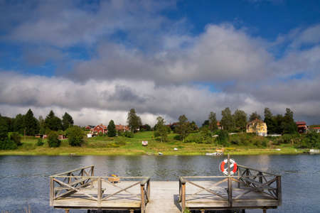 A wooden jetty with a nice view over the Osterdalalven river close to the Swedish village Djurasの写真素材