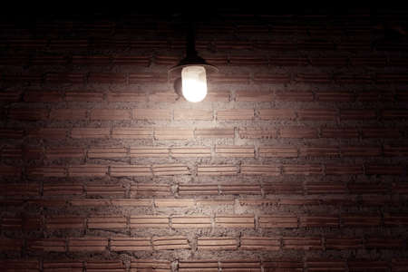 Old red brick wall background and bulbs, copy space for textの写真素材