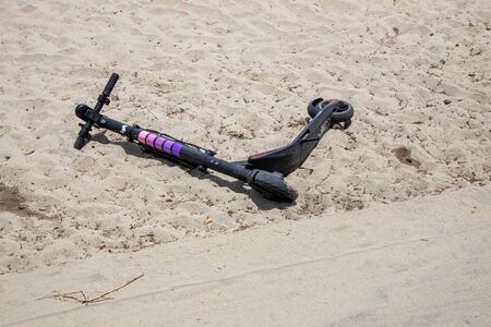 San Diego, California - Summer 2019 Scooter thrown in sand.のeditorial素材