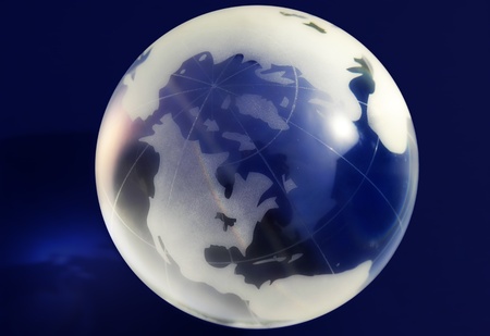 A glass globe on a blue background, lit from above  の写真素材