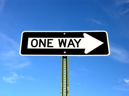 A one way sign on a blue sky
