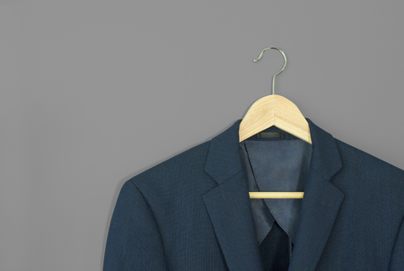 wood hanger with navy blue suit isolated on grey backgroundの写真素材