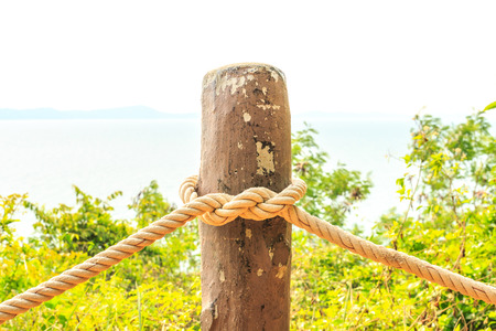 The knot of thick rope tied around a wooden stake.の写真素材