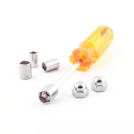 Screwdriver and hexagon domed cap nuts on white background.