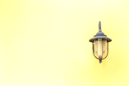 Old electric lamp on yellow wall.の写真素材