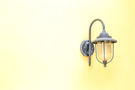 Old electric lamp on yellow wall.