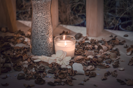 Dry flowers and stone in a vase near candlelight vintage home decor, dark tones.の写真素材