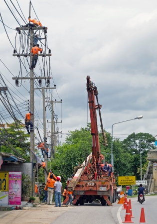 RATCHABURI, THAILAND - AUGUST 24: Electricians are installing electric post and wiring connections on August 24, 2013 in Ratchaburi, Thailand.のeditorial素材