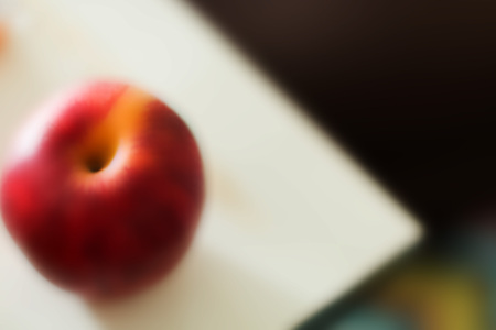 Red apple on white plate in blurred by effect from graphic program.の写真素材