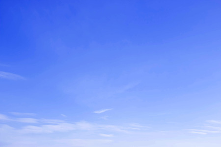 Blue sky background with little soft thin clouds lies at the bottom of photo.の写真素材
