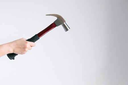 A hand of woman holding a hammer in concept of lady in present that can repair home appliance by themselves.の写真素材