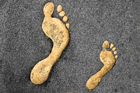 Golden right feet prints in a rocky surfaceの写真素材