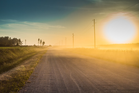 Country dirt road in the light of the sunset, in the summer, HDR effectの写真素材
