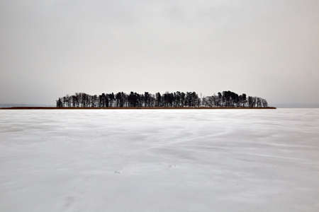 Baltezers, Latvia: small island in a frozen lake in snowy winterの写真素材