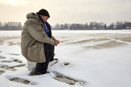 January 21, 2021, Baltezers, Latvia: fisherman on a frozen lake from a  right sideのeditorial素材
