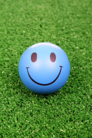 Blue smiley face on green grass background.の写真素材