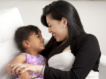 Mother and girl smiling in the living room white の写真素材