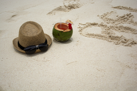 Summer hat and sunglasses with coconut on a sunny beach.

の写真素材