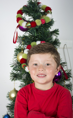 Portrait of happy little boy in near Christmas tree.の写真素材