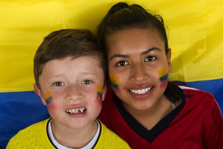 Two brothers with the flag are watching a game and totally excited.の写真素材