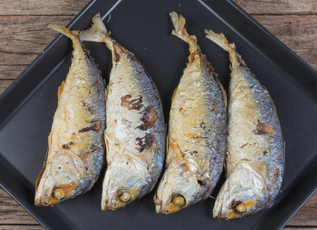 Fried shortbodied mackerel with wooden backgroundの写真素材