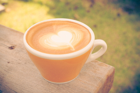Cup of Hot Art Latte Coffee on table wooden,vintage colorの写真素材