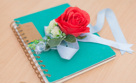 Red roses and notebook on wood background, love conceptの写真素材