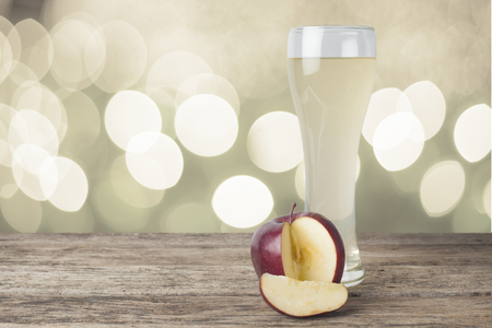 apple juice on the wooden table,bokeh backgroundの写真素材