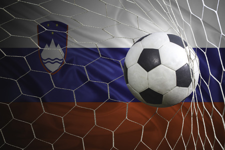 Slovenia flag and soccer ball, football in goal netの写真素材
