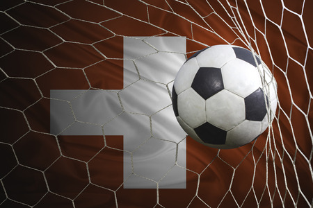 Switzerland flag and soccer ball, football in goal netの写真素材