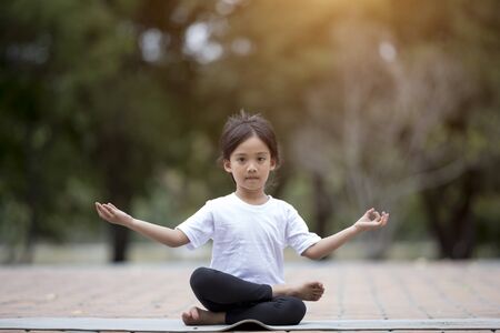 beautiful Asian children meditating in lotus positionの写真素材