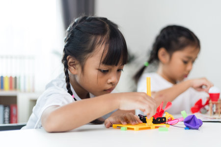 two sibling Asian girl playing windmill stacks at home