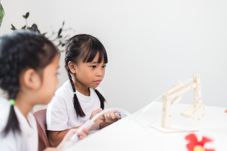two Asian girl is studying the work of work of mechanical grip on the hydraulic-poweredの写真素材