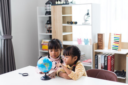 two sibling Asian studying geography at home.の写真素材