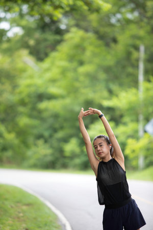 A young woman warms up on a treadmill during her morning workout, her steps rhythmic and steady, as...