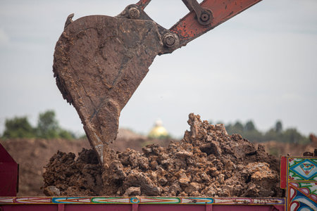 Excavator working on a construction site. Backhoe digs a hole in the ground.