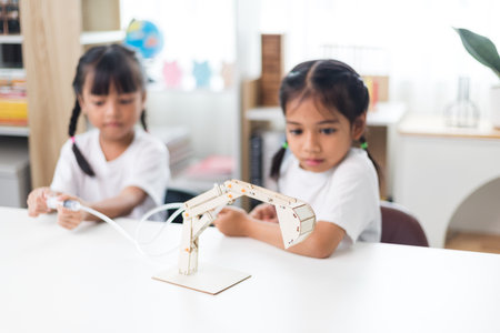 two Asian girl is studying the work of work of mechanical grip on the hydraulic-poweredの写真素材