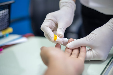 A person is blood draw and a small yellow object. The person is wearing gloves and he is a medical...