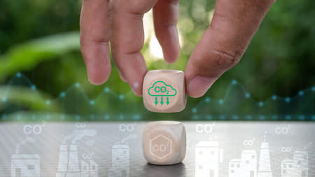 A hand holding two wooden cubes with CO2 on them. The cubes are stacked on top of each other