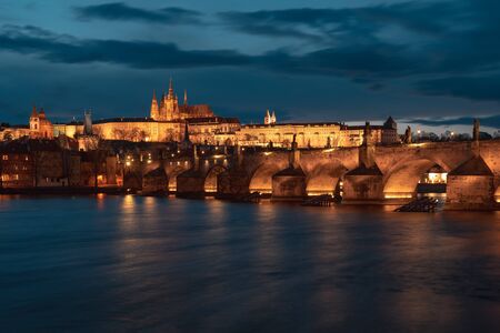 St. Vitus Cathedral with the charles bridge at the sunset and Prague by night.の写真素材
