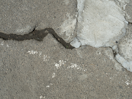 Cracked asphalt patched with cementの写真素材
