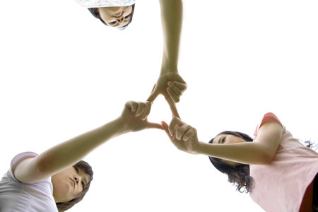 Three girls standing on lawn with hands together