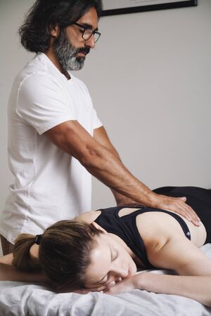 male kinesiologist performing physical therapy of the spineの写真素材