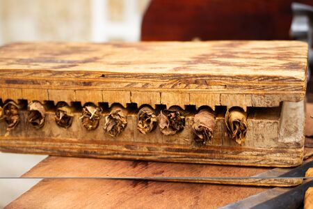 Wooden box with handmade cigars inside while they are being pressedの写真素材