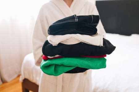 Girl carrying a pile of folded clothesの写真素材