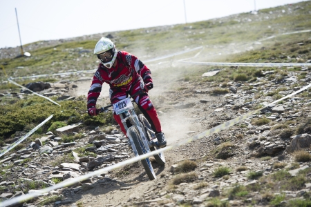 GRANADA, SPAIN - JUNE 30: Unknown racer on the competition of the mountain downhill bike "Bull bikes Cup DH 2013, Sierra Nevada " on June 30, 2013 in Granada, Spainのeditorial素材