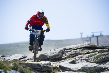 GRANADA, SPAIN - JUNE 30: Unknown racer on the competition of the mountain downhill bike "Bull bikes Cup DH 2013, Sierra Nevada " on June 30, 2013 in Granada, Spainのeditorial素材