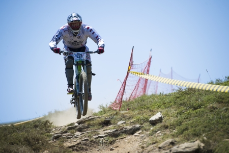GRANADA, SPAIN - JUNE 30: Unknown racer on the competition of the mountain downhill bike "Bull bikes Cup DH 2013, Sierra Nevada " on June 30, 2013 in Granada, Spainのeditorial素材