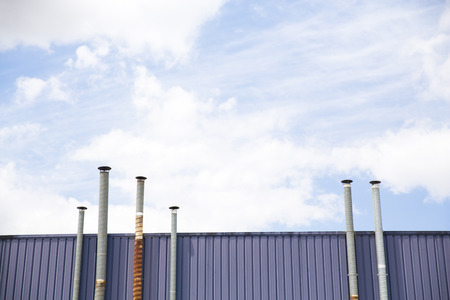 Six ventilation pipes over blue sky closeup on industrial placeの写真素材